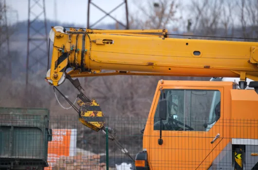 Caminhão Munck em operação, utilizado para içamento e transporte de cargas pesadas em obras.
