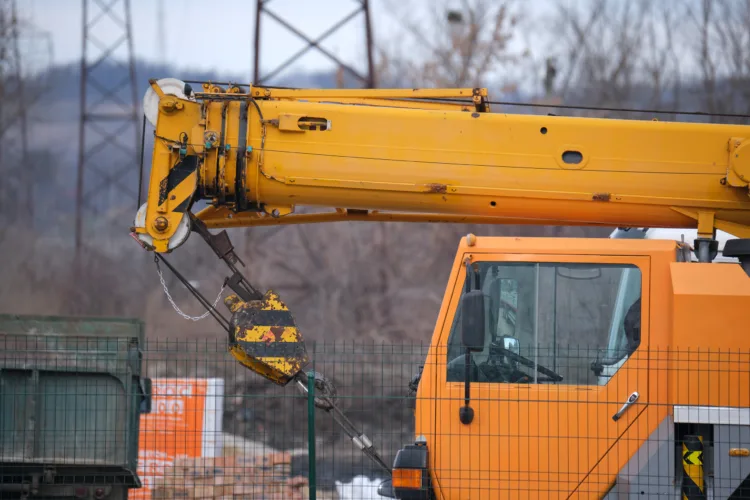 Caminhão Munck em operação, utilizado para içamento e transporte de cargas pesadas em obras.