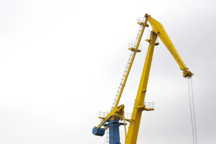 guindaste articulado amarelo utilizado em obras de construção civil para movimentação de cargas pesadas